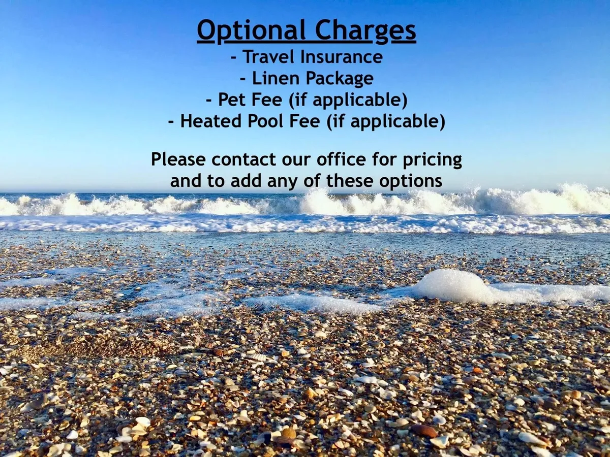 A serene stretch of sandy beach meets gentle ocean waves under a clear blue sky, dotted with seashells and perfect for swimming, sunbathing, or building sandcastles. The shoreline is wide and pristine, ready for endless family fun right at your doorstep.